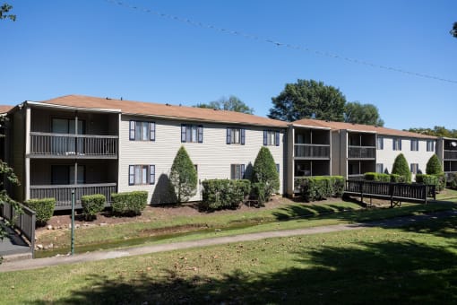 an exterior view of an apartment building with lawns and trees