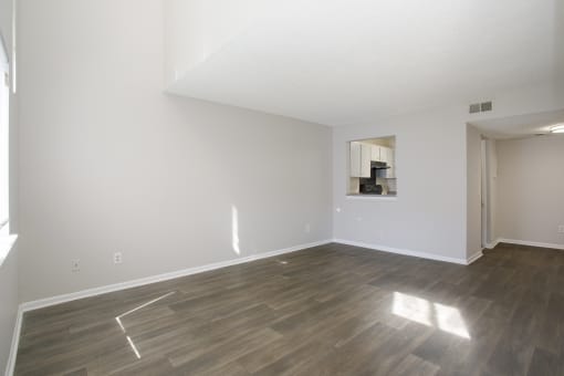 an empty living room with white walls and wood floors