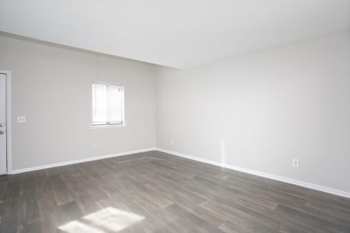 an empty living room with white walls and wood floors