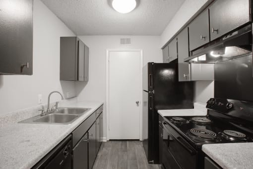 a kitchen with black appliances and white counter tops