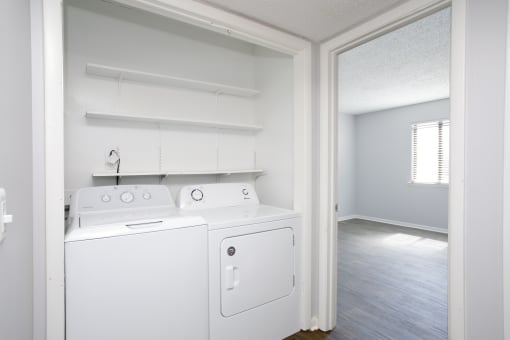 an empty laundry room with a washer and dryer in it