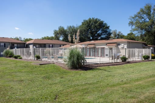 a house with a yard and a fence in front of it