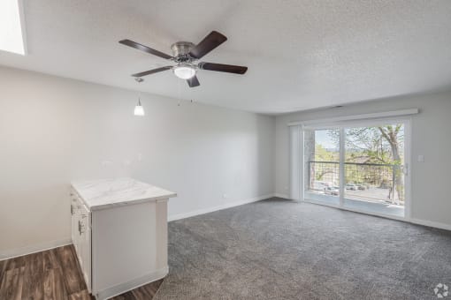 a bedroom with a large window and a ceiling fan