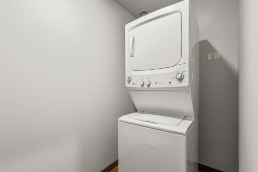 a washer and dryer in a room with a white wall and a white