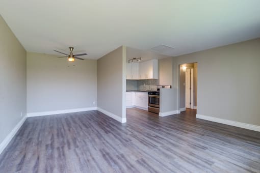 Colton Apartments for Rent - Las Brisas Living Room with Stylish Decor, Beige and Grey Walls, Plank Flooring, Large Window, and Popcorn Ceiling