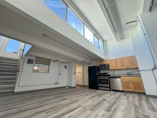 an open living room with a kitchen and a staircase