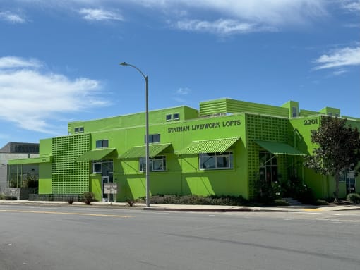 a bright green building with green shutters and a street light
