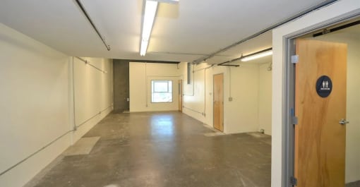 an empty room with a wooden door and white walls