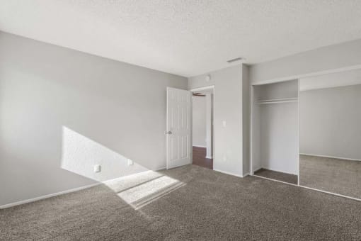 an empty room with a white door and gray carpet at Aspire Rialto, Rialto, CA