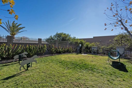 a backyard with a grassy area and a fence at Aspire Rialto, Rialto California