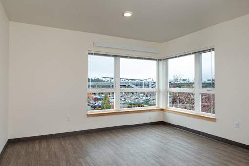 A room with a large window overlooking a parking lot.