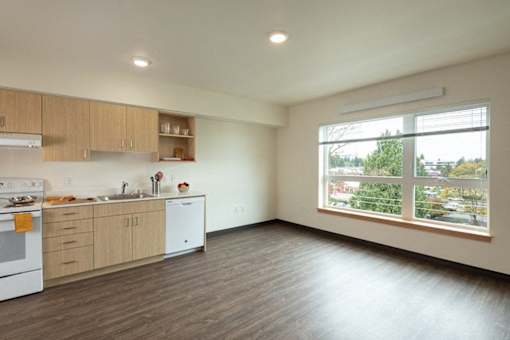 A kitchen with wooden floors and white appliances.