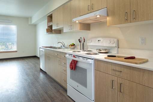 A kitchen with a white oven and wooden cabinets.