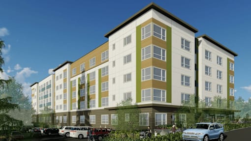 A modern apartment building with cars parked in front.