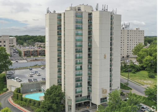 a view of a tall building from above with a parking lot