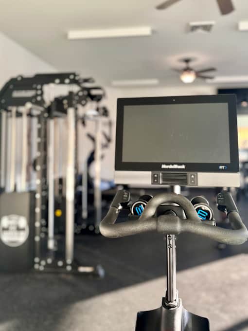 A stationary exercise bike with a monitor attached to the handlebars.