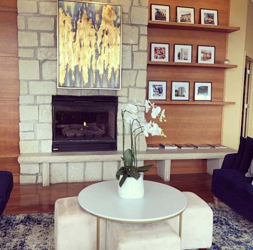 a living room with a stone fireplace and a white coffee table