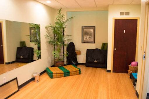 a room with a wooden floor and a large mirror
