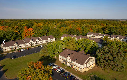 A large building surrounded by trees in the fall.