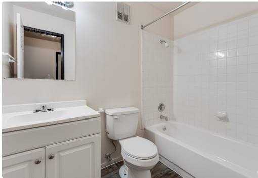 A white toilet sits next to a white sink in a bathroom.