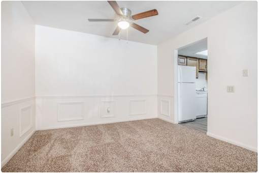 A room with a ceiling fan and a carpeted floor.