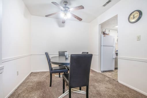 A dining room with a table and chairs.
