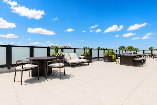 A patio with a table and chairs overlooking a cityscape.