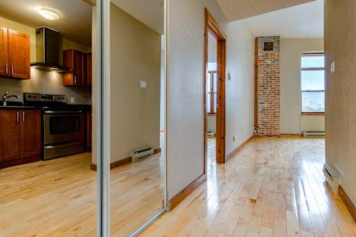 A room with a wooden floor and a brick wall.