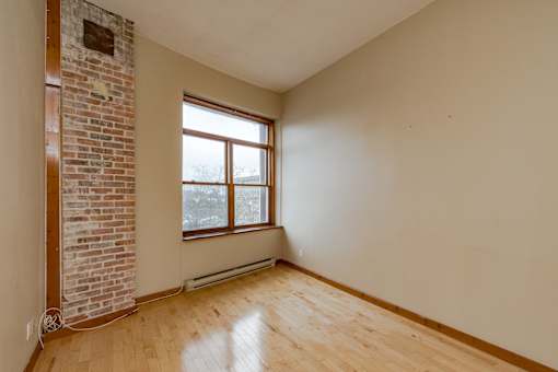 A room with a brick wall and a window.