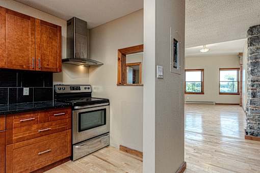 A kitchen with wooden cabinets and a black countertop.
