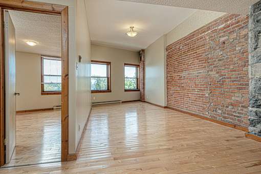 A room with wooden floors and a brick wall.