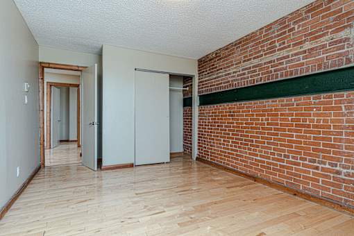 A room with a brick wall and wooden flooring.