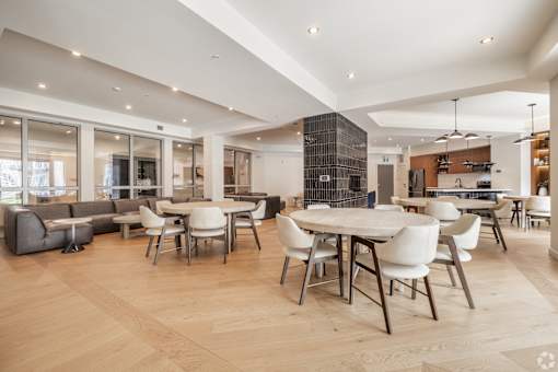 A modern dining room with a large table surrounded by chairs.