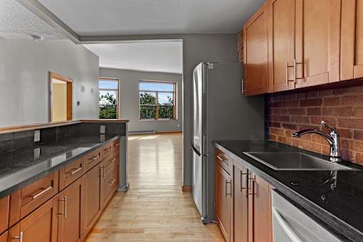 A kitchen with wooden cabinets and a black countertop.