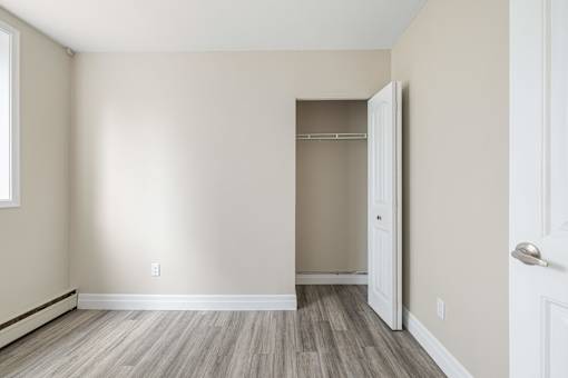 A room with a white door and a window on the left.