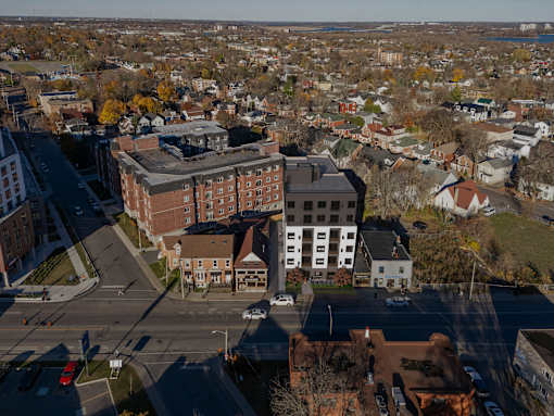 A view of a city from above with buildings, cars, and trees.