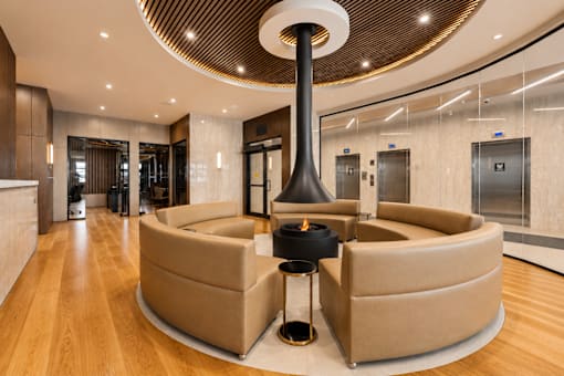 A modern living room with a large circular table and a fireplace.