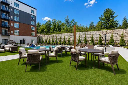 A patio with a table and chairs is surrounded by a stone wall.
