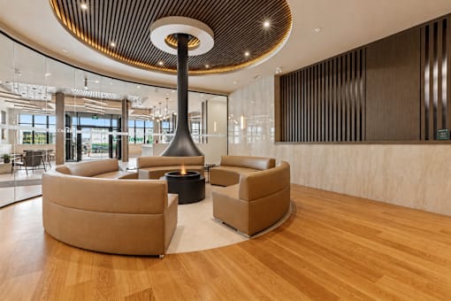 A modern living room with a large circular light fixture and two round sofas.