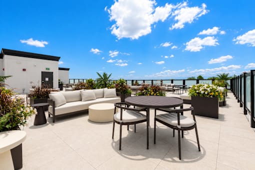 A patio with a table and chairs overlooking a body of water.