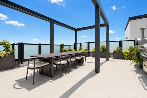 A table surrounded by chairs on a patio.