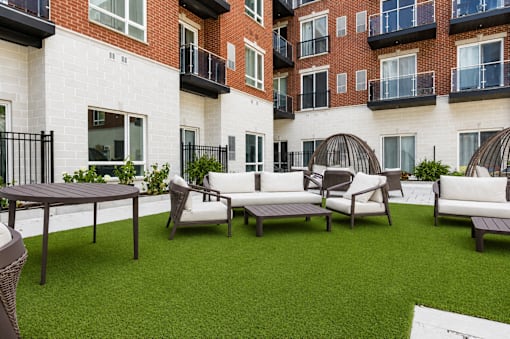 A patio with a table and chairs is surrounded by a brick building.
