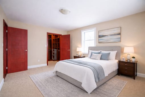 A bedroom with a large bed and a red door.