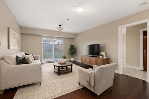 A living room with a couch, chair, and television.