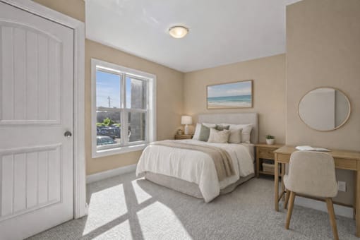 A bedroom with a bed, desk, and chair.