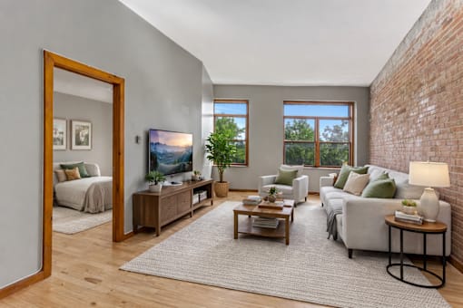 A living room with a grey couch, a wooden coffee table, and a large mirror.
