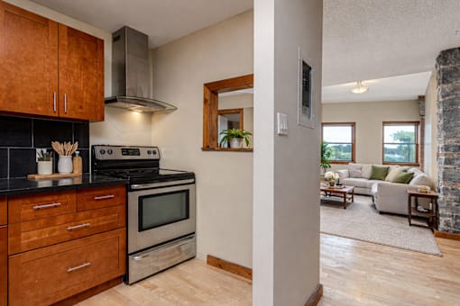 A kitchen with wooden cabinets and a stainless steel oven.