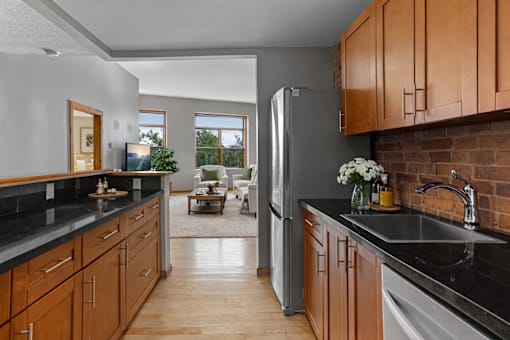 A kitchen with wooden cabinets and a black countertop.