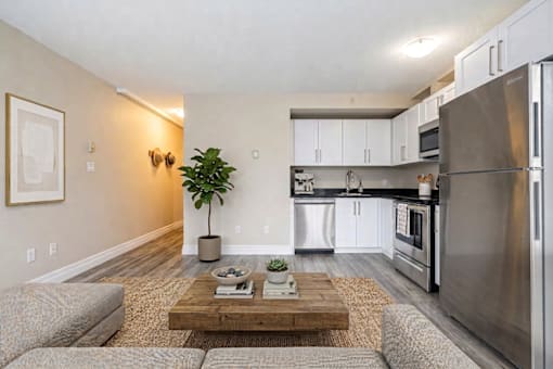 A modern kitchen with a refrigerator, microwave, and oven.