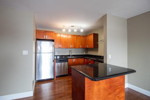 A kitchen with wooden cabinets and a black counter top.